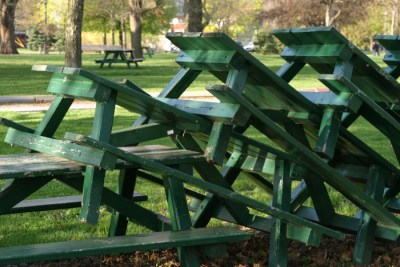 Green benches stacked together in the park.