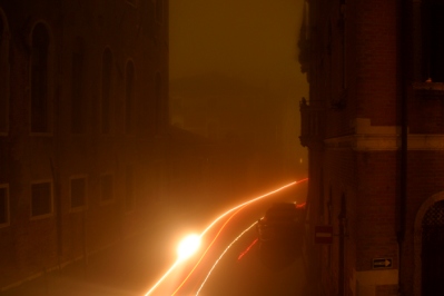 Lights of a boat passing through foggy Venice